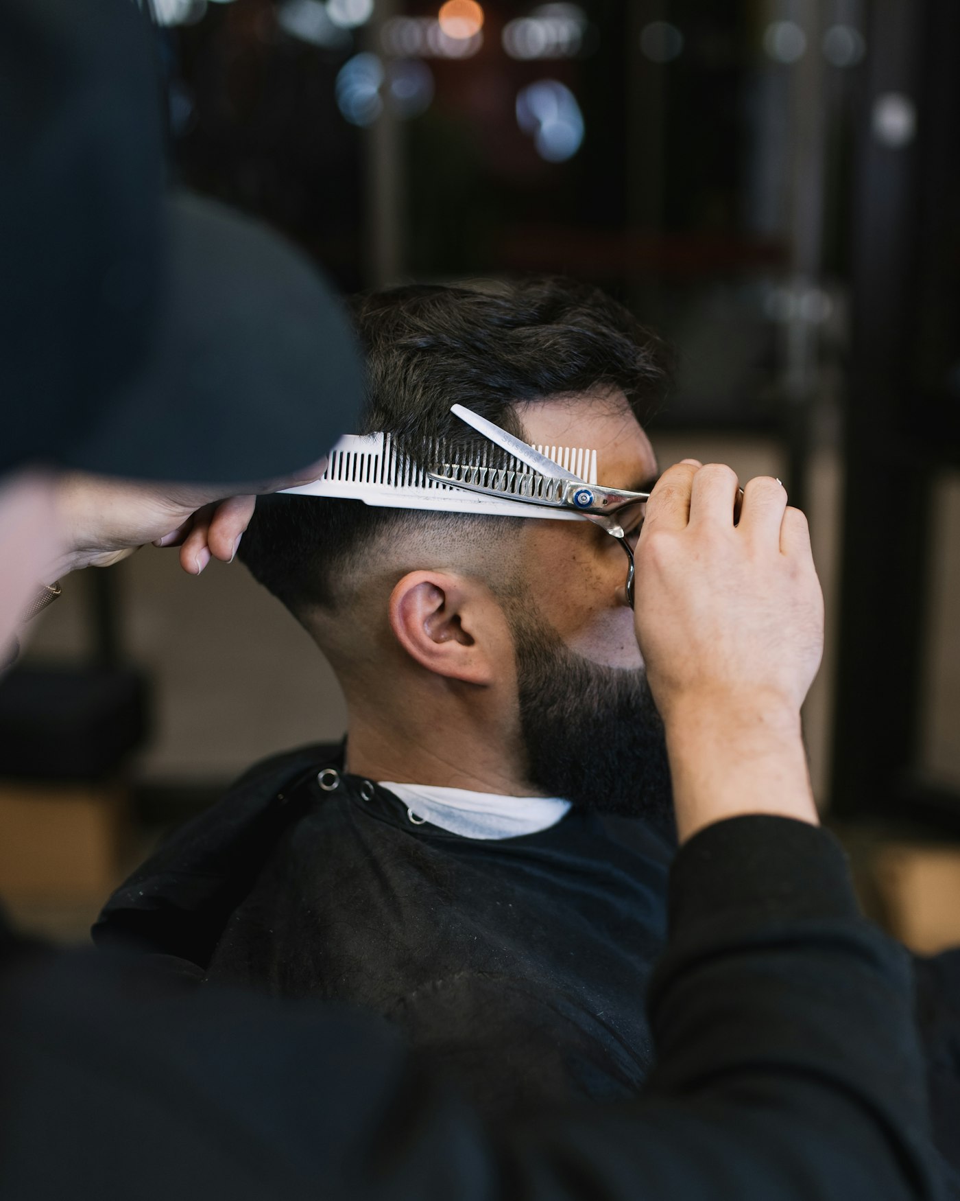 Barbeiro atendendo cliente na cadeira, representando o MEI formalizado de barbearia